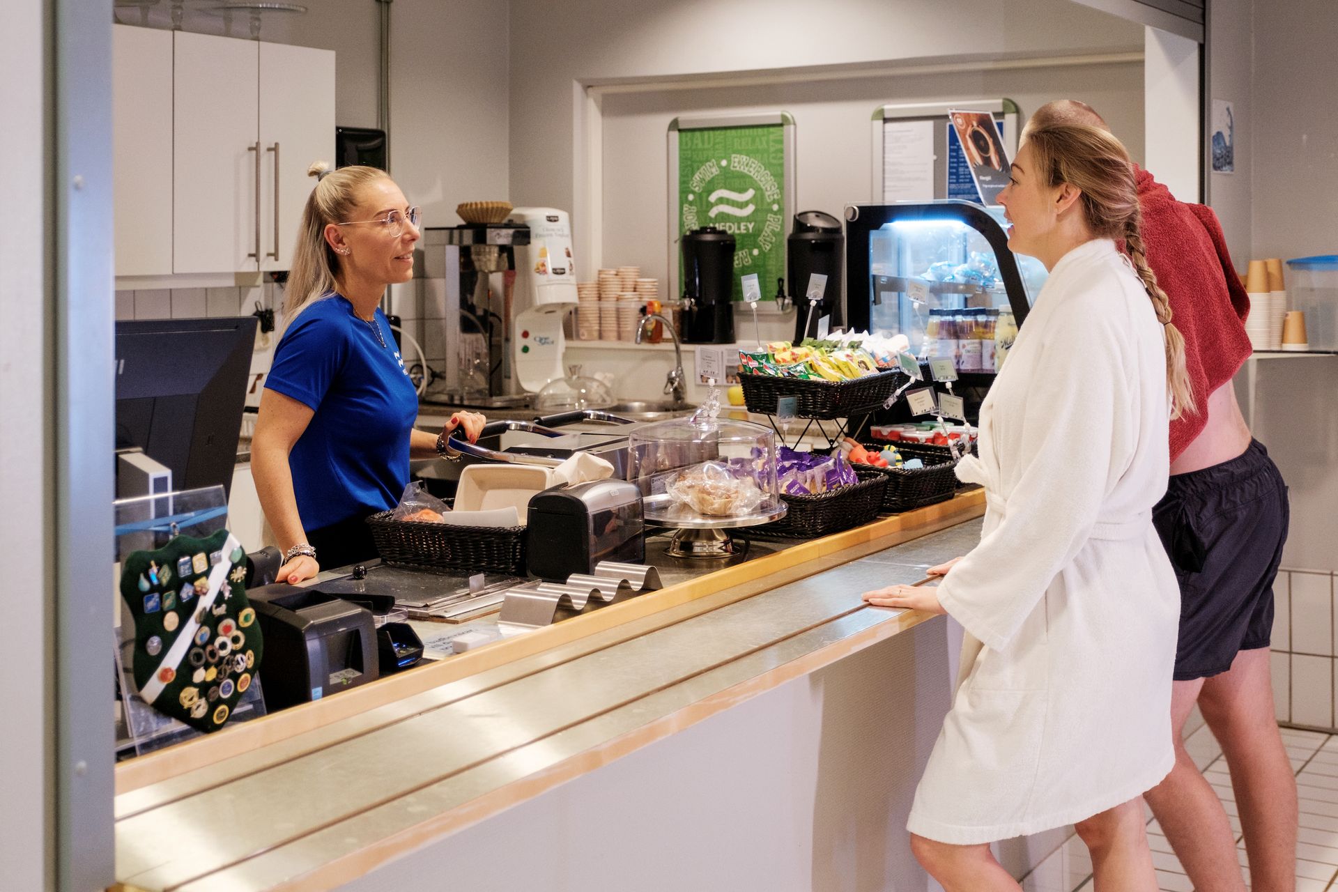 Bild på en kvinna i morgonrock som beställer någon från cafet inne på vattenpalatset