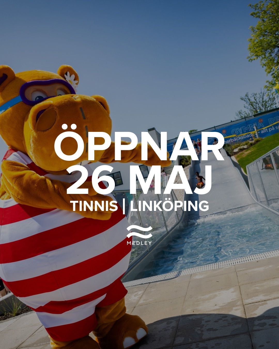 En person i en flodhästdräkt med röda och vita ränder står vid en vattenrutschkana under en klarblå himmel. Texten över bilden lyder: Öppnar 26 maj, Tinnis | Linköping, Medley.