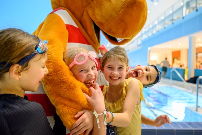 Bild på barn som ler och kramar Flodis.