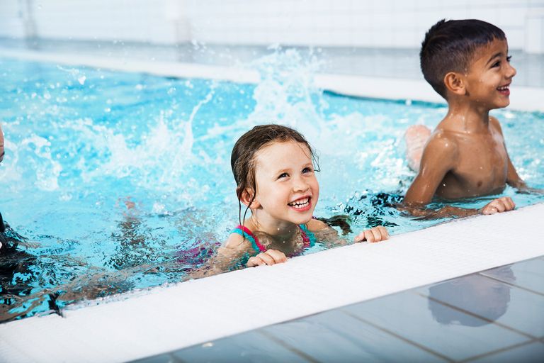 Bild på leende barn i en pool.