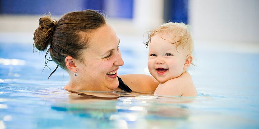 Bild på en mamma och en bebis i en pool.