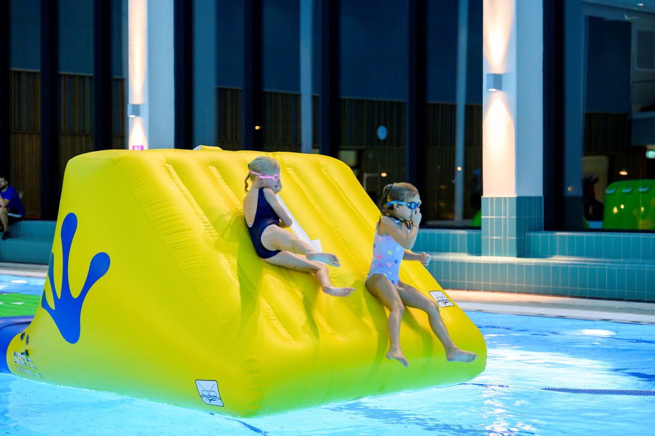 Bild på barn som glider ner i en pool.
