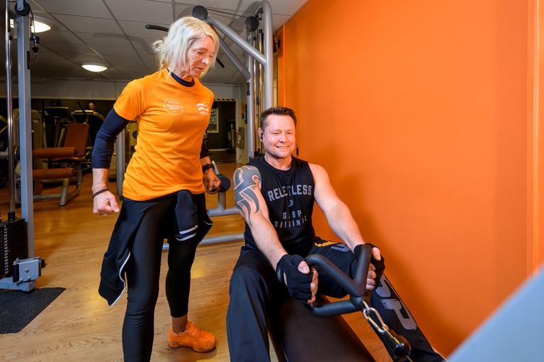 Bild på medley instruktör som coachar en medlem i gymmet
