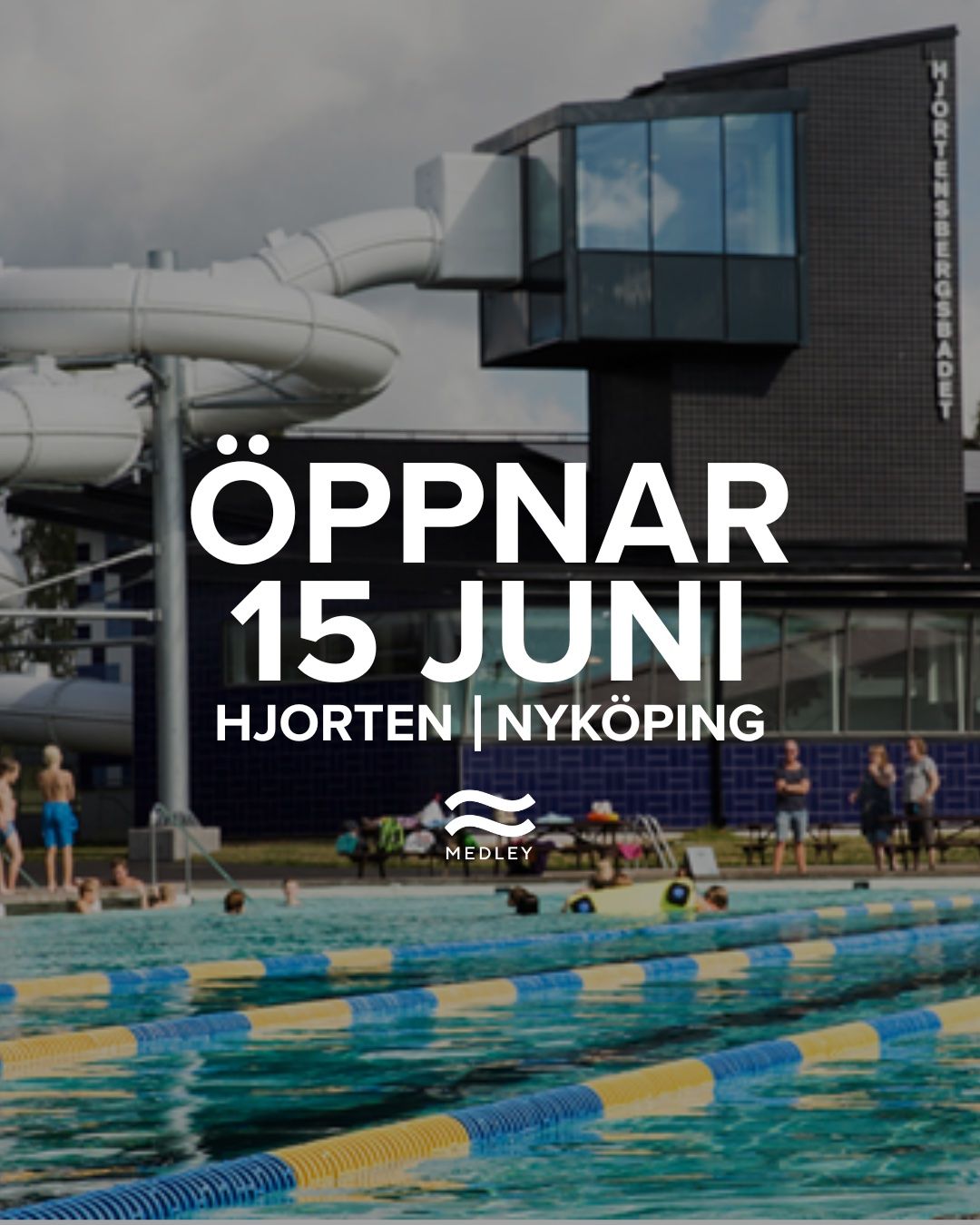 Utomhuspool med människor som simmar och kopplar av. Stora rutschkanor och en modern byggnad i bakgrunden. Överlagrad text på svenska lyder: Öppnar 15 juni. Hjorten | Nyköping. Medley.