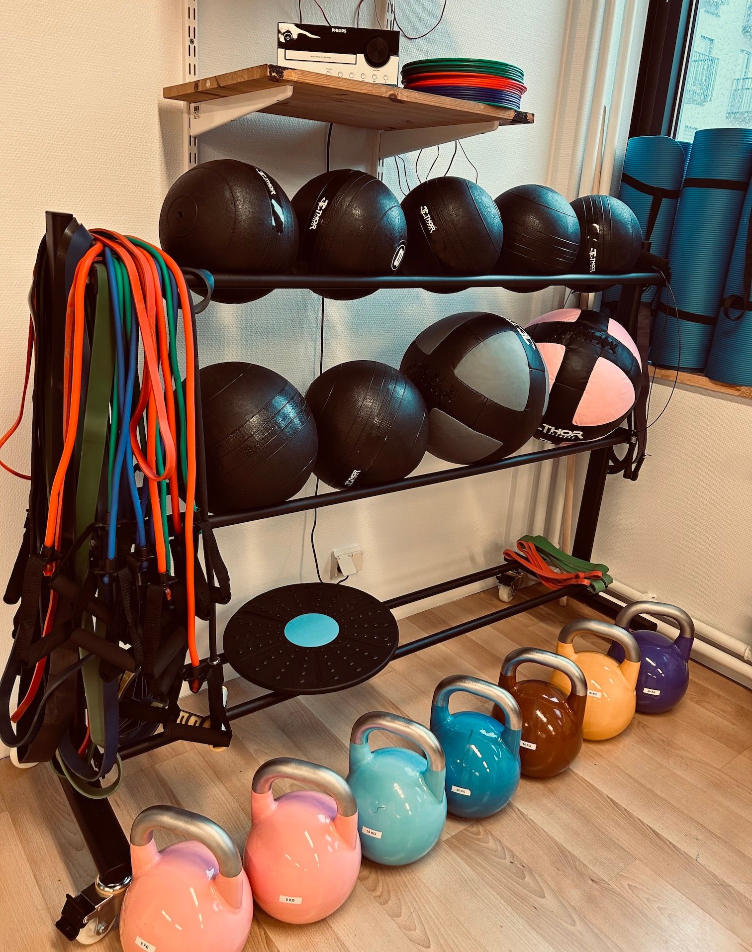 Bild på gummiband , kettlebells och medicinbollar i olika färger och vikter