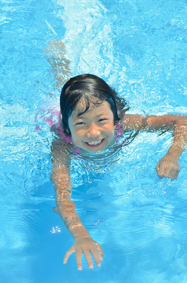 Bild på ett barn som simmar i en pool.