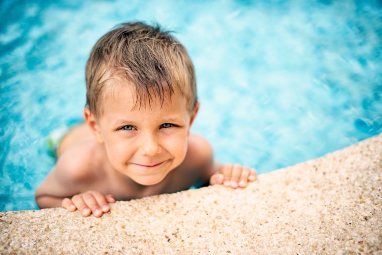 Bild på ett leende barn i en pool.