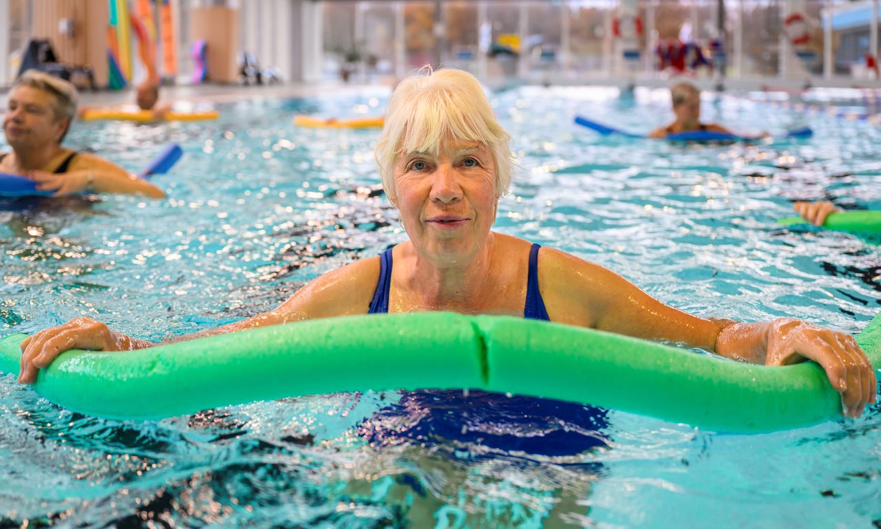 Bild på inzoomad kvinna i bassäng medan hon tränar med en noodle