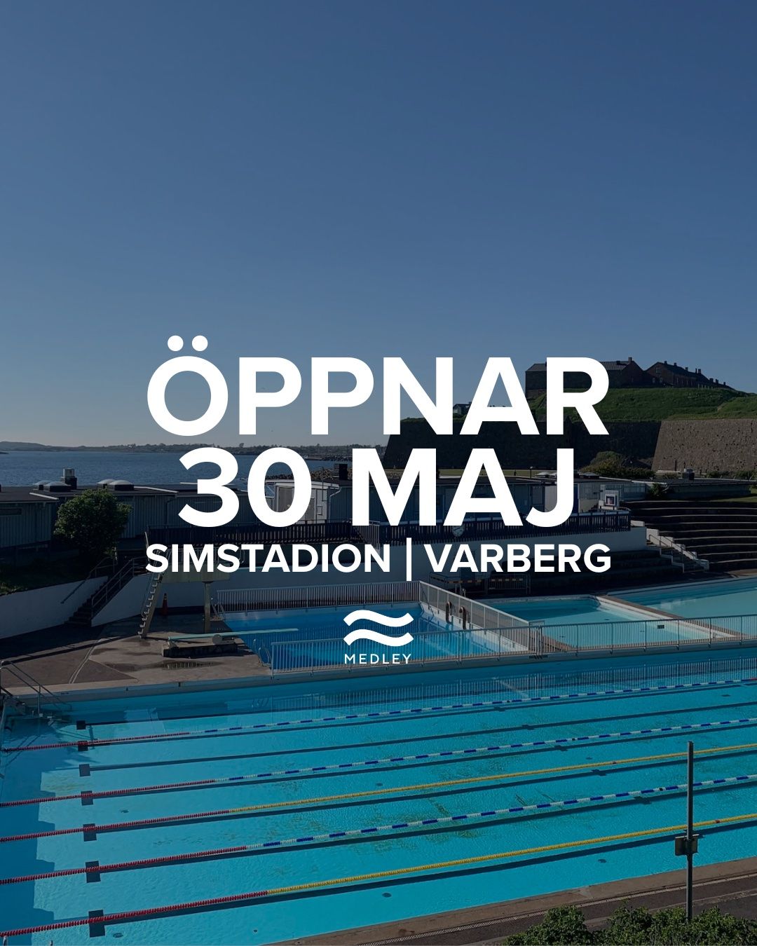Utomhuspool med blått vatten, tomma banor och en naturskön bakgrund med havet och en grön kulle. Stor text lyder: Öppnar 30 maj Simstadion Varberg med Medley-logotypen under.