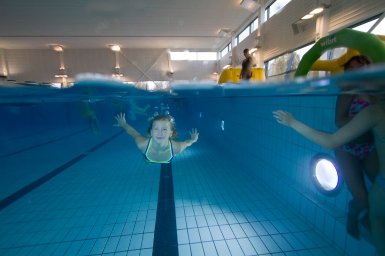Bild på ett barn som simmar under vattnet.