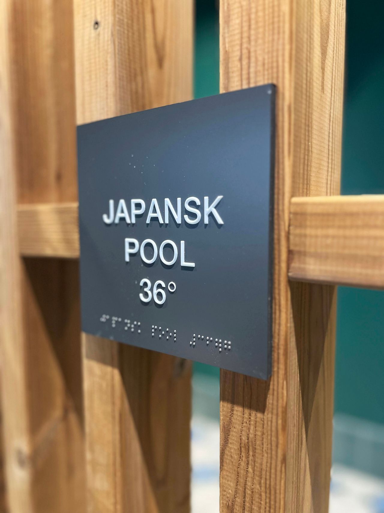 Bild på skylten till japanska poolen som även har blindskrift